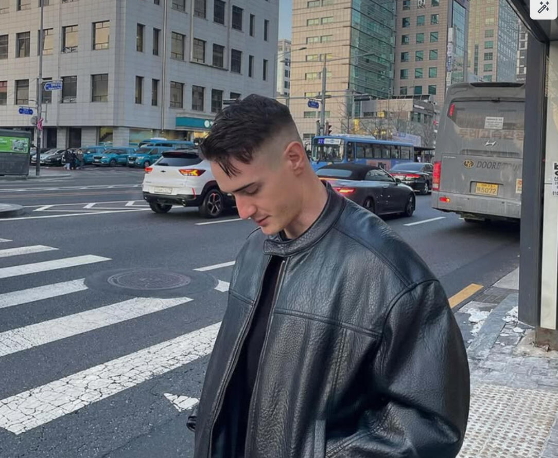 Man with a fresh skin fade haircut from Cutters Men’s Hair barbershop in Hongdae, Seoul, wearing a black leather jacket on a city street